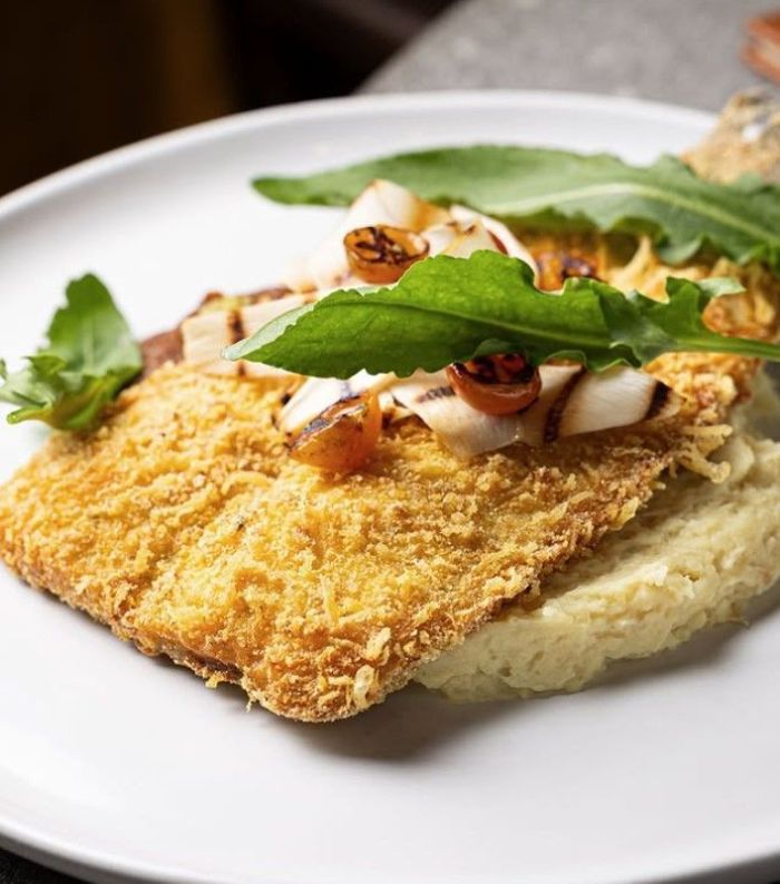 Peixe Frito: truta em crosta de fubá e Queijo D’Alagoa, acompanhada de purê de tomate e de pupunha assada, finalizado com azeitona, delicadas lascas de palmito e folhas de azedinha