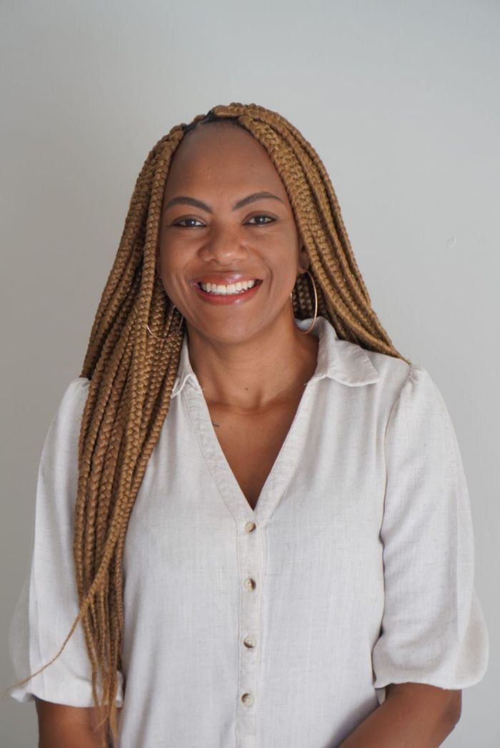 Daphiny é uma mulher preta, de tranças box braids loiras. 