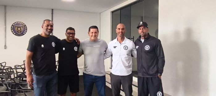 Quatro homens unidos em abraço 
