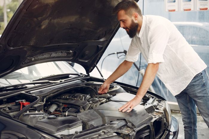 Homem inspeciona motor em oficina