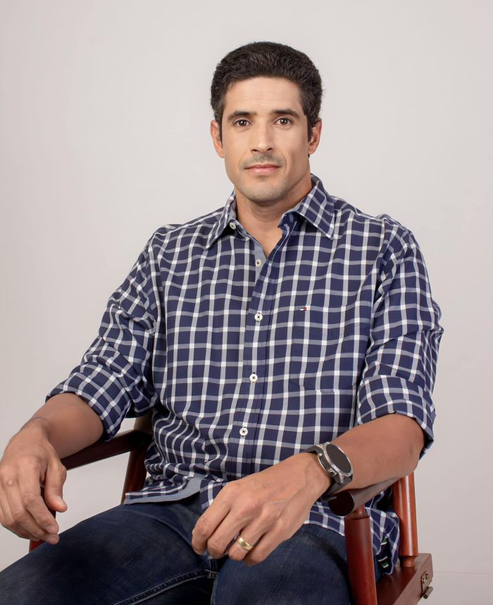 Kiko Marinho é um homem branco, de cabelo preto com fios brancos. Na imagem, ele usa uma camisa xadrez. 