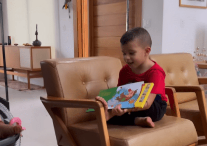 Gaspar, de 4 anos, lê história bíblica para Maria Guilhermina