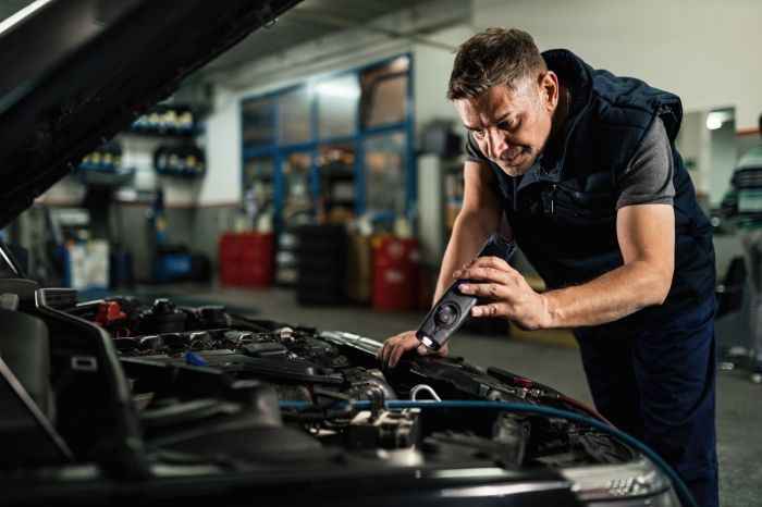 Mecânico examina motor de carro
