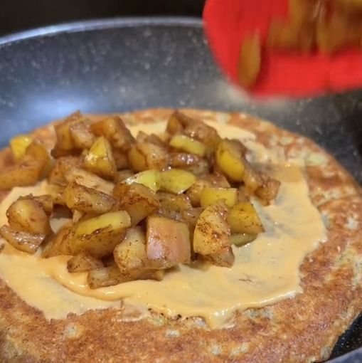 Panqueca de maçã com um creme e pedaços de maçã por cima 