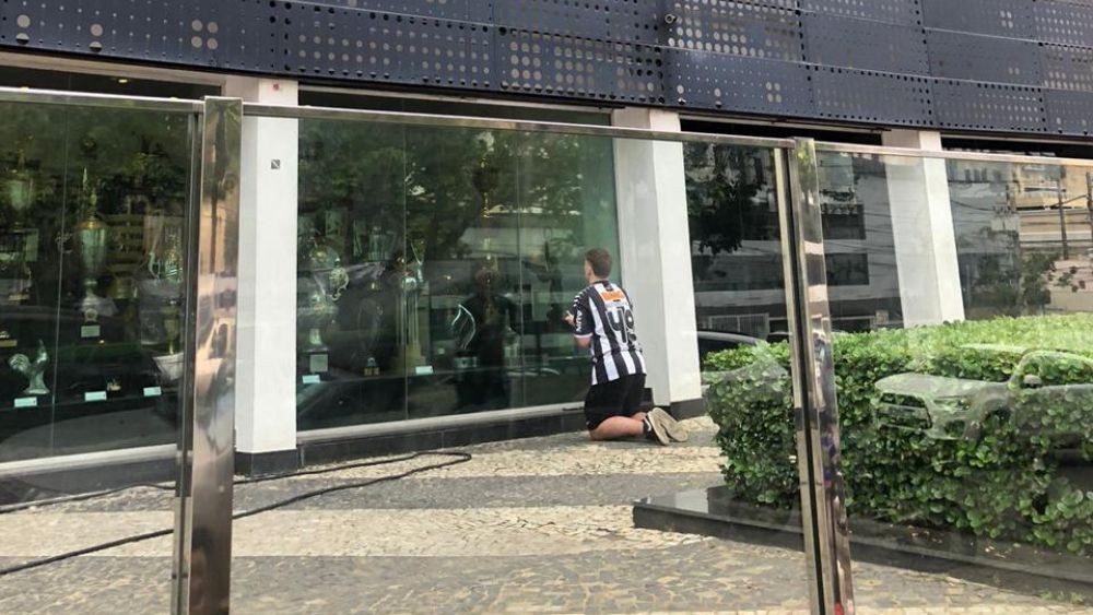 Atleticano reza em frente à taça da Libertadores na sede de Lourdes antes de final
