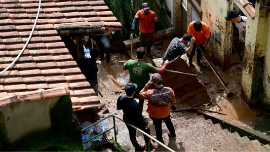 Volunteers search for victims amid the rubble and mud of a house after a landslide triggered by heavy rains in the Paineiras neighborhood in Juiz de Fora, Minas Gerais State, Brazil, on February 25, 2026