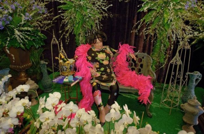 A socialite Mickey Easterling foi velada sentada em um banco, segurando um cigarro e um copo de champagne