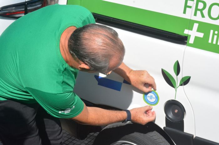 Marcelo cola o selo num dos carros da frota do Sebrae
