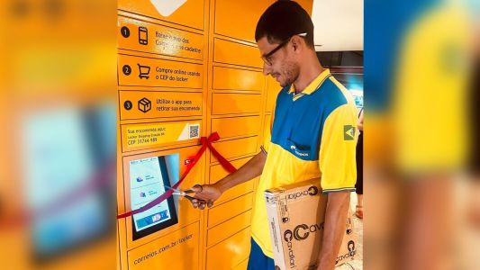 Carteiro, Edson Junior de Oliveira, inaugurando oficialmente o 1º Locker dos Correios de Minas e depositando encomenda real para retirada do cliente.