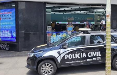 Imagem mostra carro da Polícia Civil estacionado na frente de uma farmácia Droga Clara
