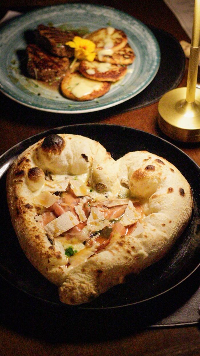 Pizza Amore al Tartufo, em formato de coração, com creme de três queijos, cogumelos, presunto Parma e mel trufado Pizza Amore al Tartufo, em formato de coração, com creme de três queijos, cogumelos, presunto Parma e mel trufado