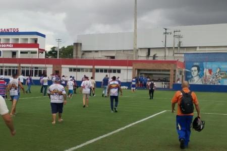 Torcedores do Fortaleza no gramado de um dos campos do CT Alcides Santos