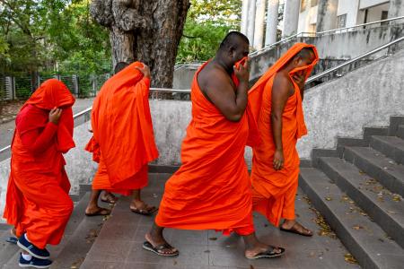 Monges presos no Sri Lanka escondem o rosto enquanto são levados à audiência de custódia