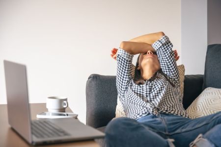 Mulher cansada do trabalho home office em frente a um laptop