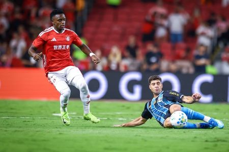 Nardoni, do Grêmio, tira bola em jogada contra Carbonero, do Inter
