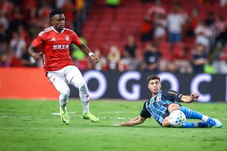 Nardoni, do Grêmio, tira bola em jogada contra Carbonero, do Inter