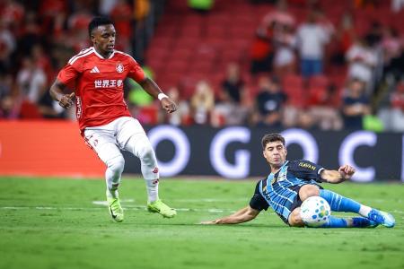 Nardoni, do Grêmio, tira bola em jogada contra Carbonero, do Inter