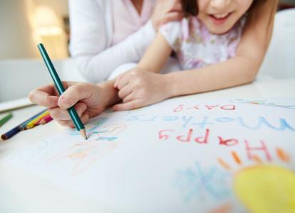 Little girl making greeting card for her mom on mothers day