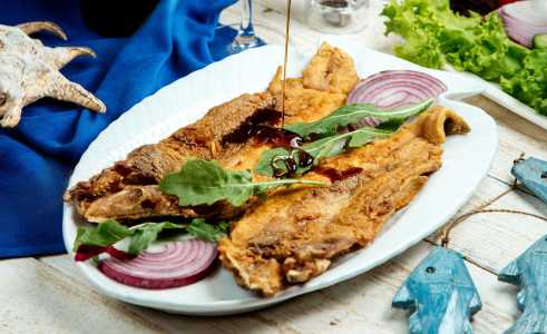Prato com peixes fritos e cebola