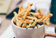 Qual a finalidade de adicionar vinagre às batatas antes de fritá-las?