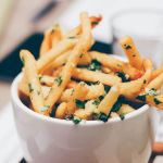 Qual a finalidade de adicionar vinagre às batatas antes de fritá-las?