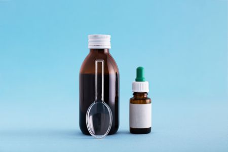 A closeup of medicine and vaccine bottles against a blue background. Vaccine, medicine, protection, COVID19, coronavirus concept
