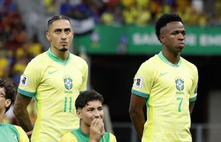 Raphinha e Vini Jr. durante execução de hino nacional antes de jogo da Seleção