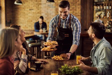 Garçom servindo pratos em um restaurante