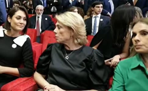 Michelle senta próxima a esposa de Moraes