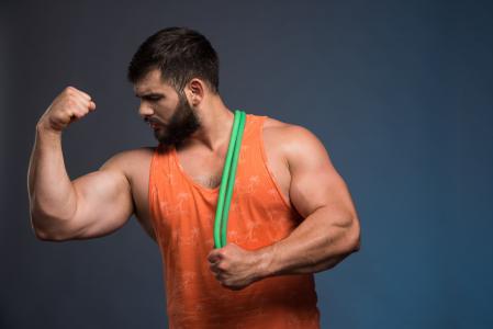 Homem flexiona bíceps em imagem do Freepik