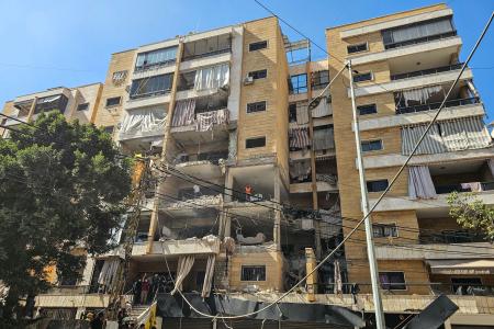 Equipes de resgate inspecionam os danos no local de um ataque aéreo israelense