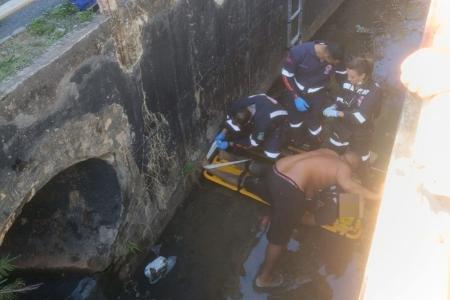 Motociclista é socorrido após bater em meio-fio e cair dentro de córrego em BH