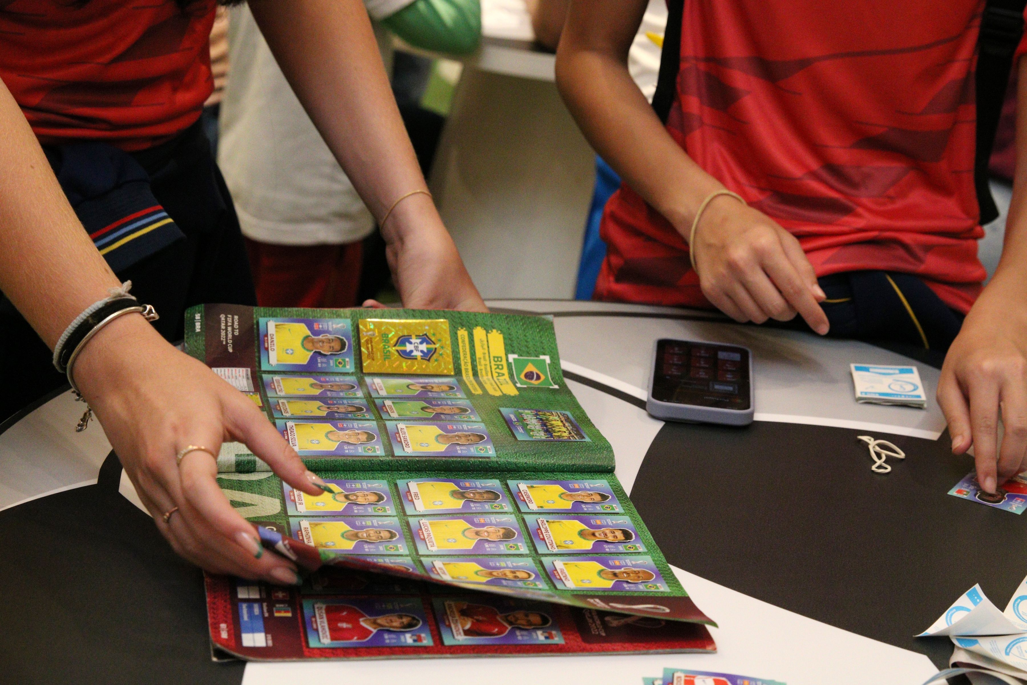Álbum da Copa: trocar figurinhas pode ajudar crianças neurodivergentes, diz psicóloga