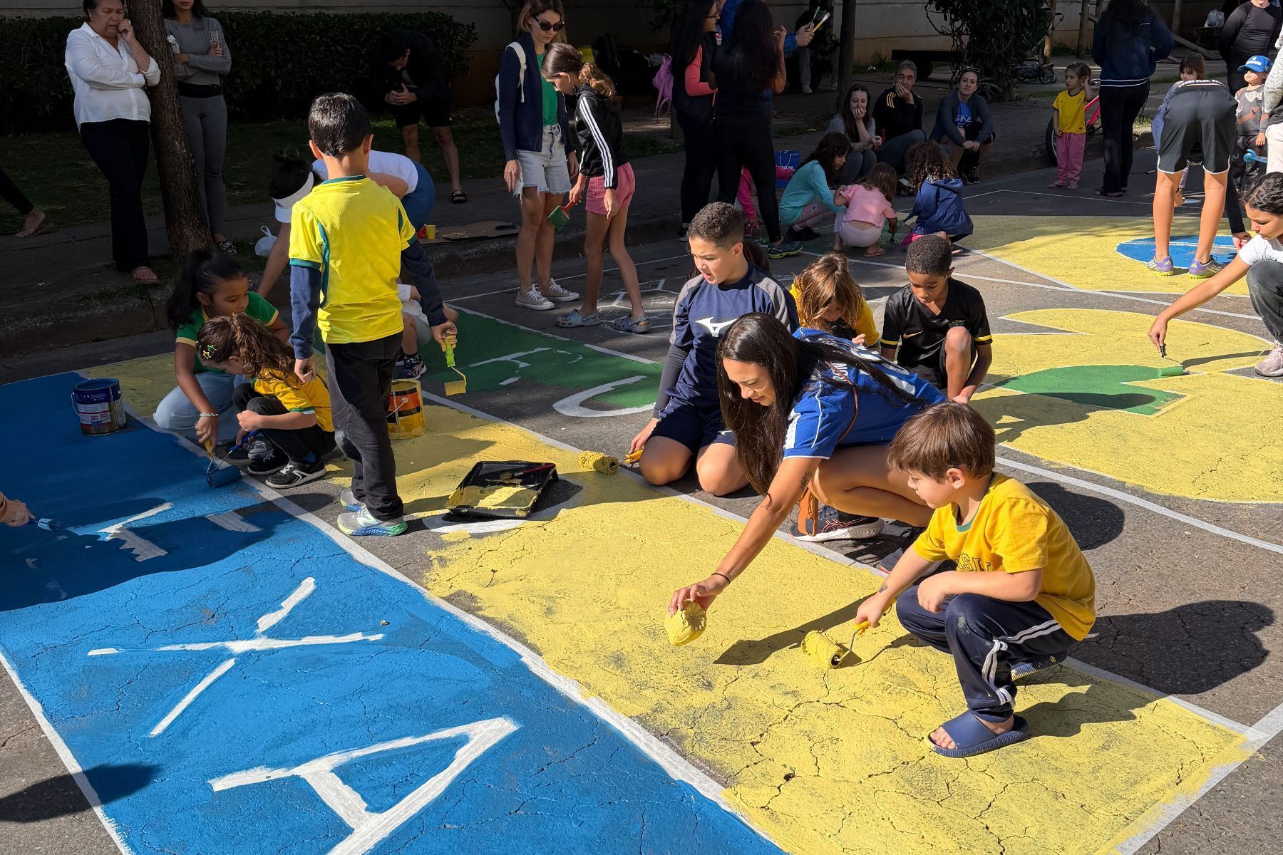 Moradores entram no ‘clima de Copa do Mundo’ e pintam rua de bairro de BH