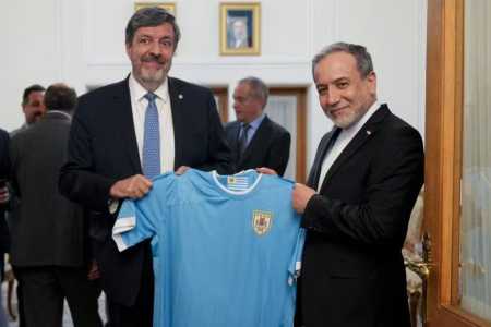 Abbas Araqchi sendo presenteado por embaixador com a camisa da Seleção do Uruguai • Divulgação / Redes Sociais