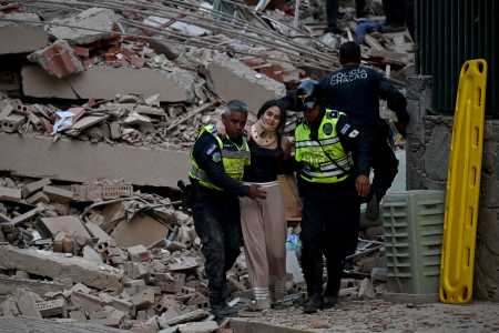 Policiais municipais evacuam uma vítima ferida de um prédio que desabou após um terremoto em Caracas, • AFP