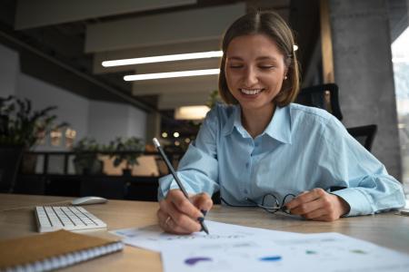 Mulher de blusa azul faz seu planejamento financeiro.
