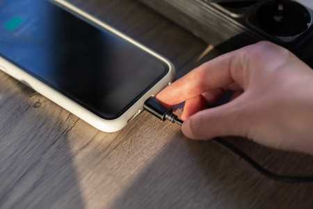 Conectando um cabo magnético a um smartphone para carregamento, em close-up