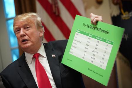O presidente dos EUA, Donald Trump, segura uma tabela de tarifas enquanto discursa na Sala do Gabinete da Casa Branca.