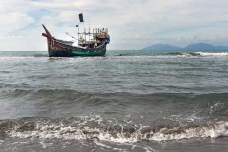 Na foto, um barco que transportou refugiados rohingya através do Mar de Andaman ancorado ao largo da costa, após os refugiados desembarcarem em uma praia em Aceh, Indonésia, em 8 de janeiro de 2023
