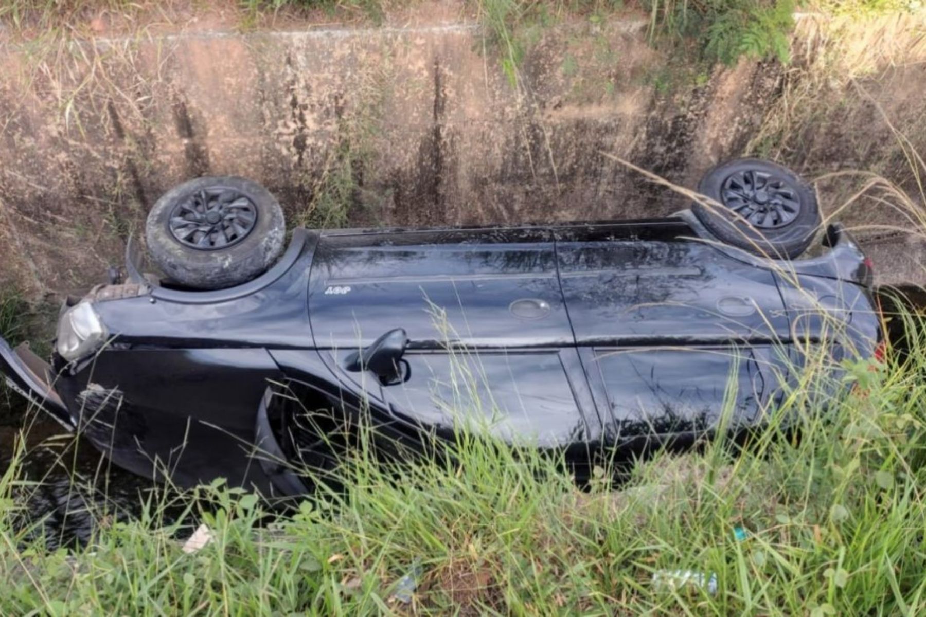 Carro capota e cai em córrego em Ribeirão das Neves