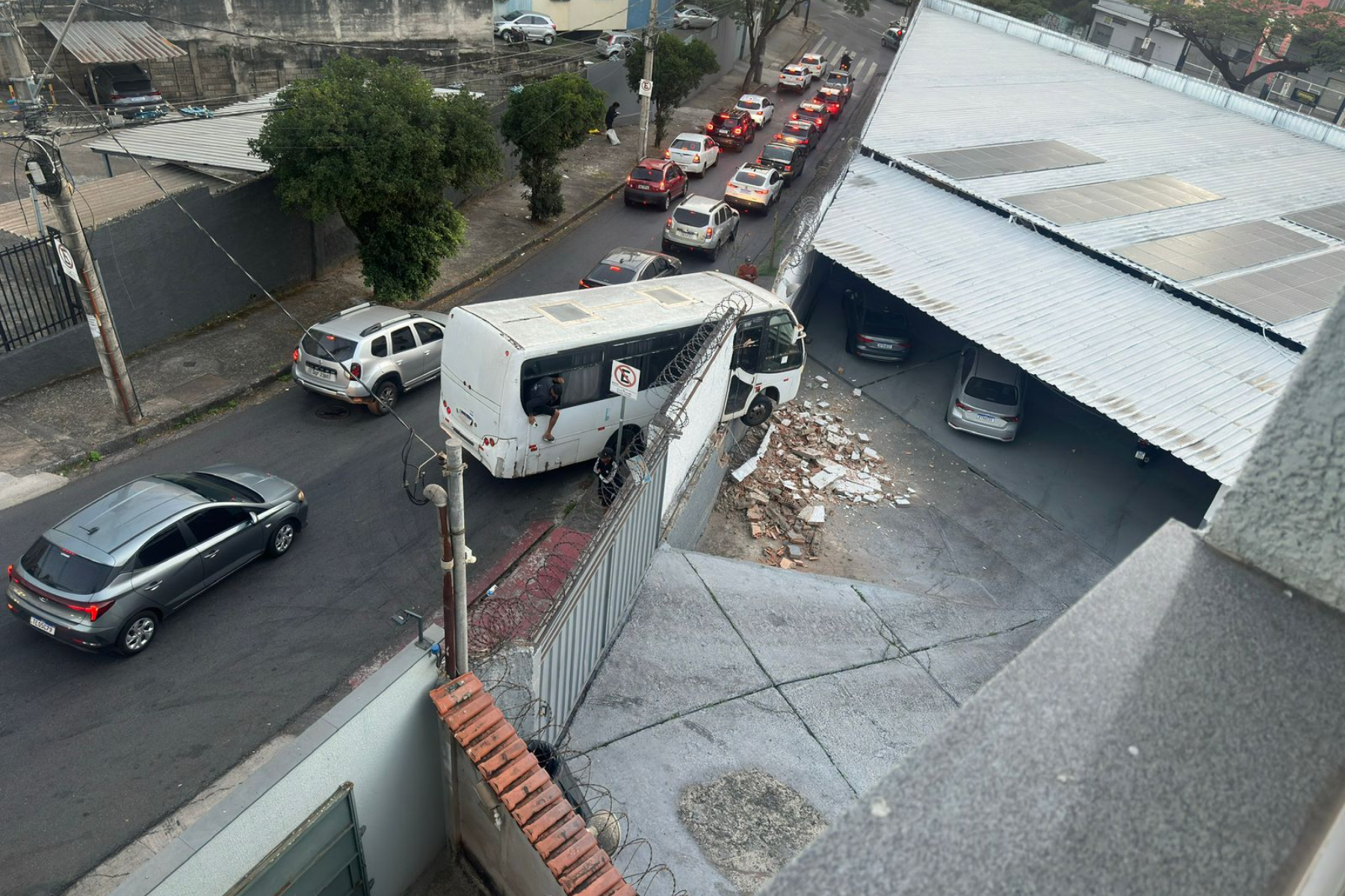 BH: micro-ônibus bate em muro e fica pendurado