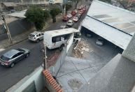 BH: micro-ônibus bate em muro e fica pendurado