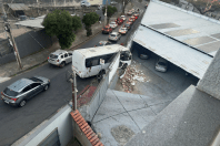 BH: micro-ônibus bate em muro e fica pendurado