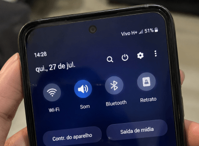 Pessoa segura celular mostrando tela com configurações do Android