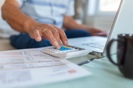 Pessoa usa calculadora para avaliar taxas de contratos de crédito.