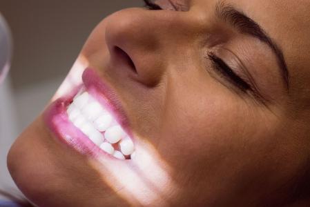 Close-up de uma paciente recebendo tratamento odontológico em uma clínica