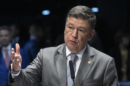 De terno cinza, bluza branca e broche dourado na lapela esquerda, Carlos Viana discursa no microfone do Senado com mão direita gesticulando