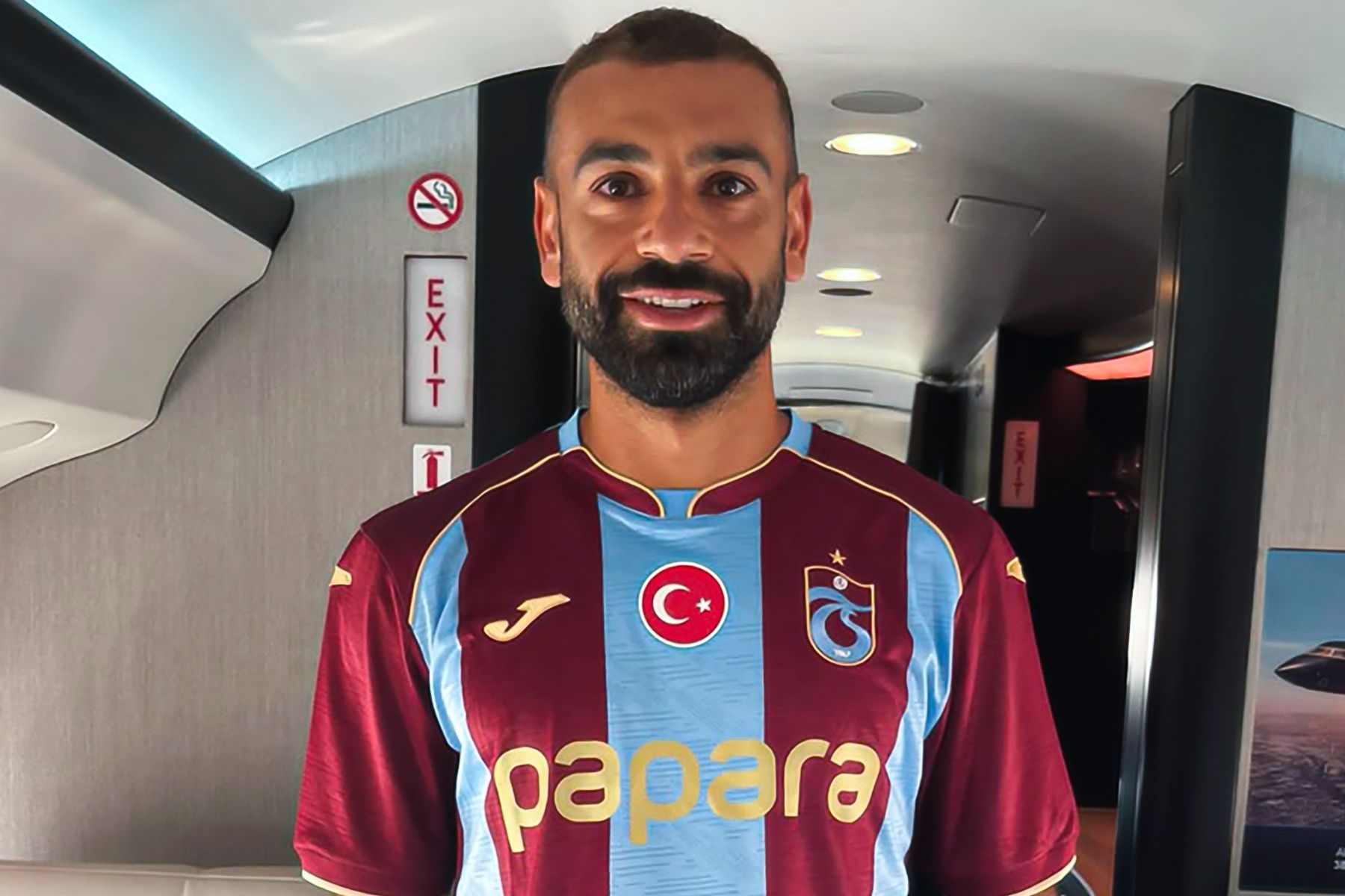 Salah veste camisa e é recebido com festa ao chegar para assinar com novo clube