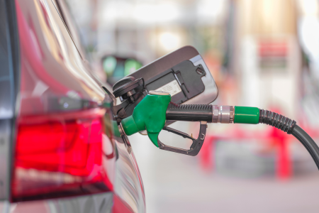 Bico de abastecimento inserido no tanque de combustível de um veículo em um posto de combustíveis.